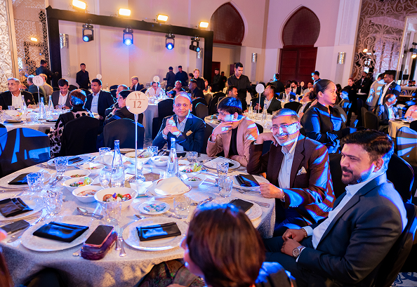 Guests seated at round tables during an LT Foods corporate gala dinner and networking event in a banquet hall.